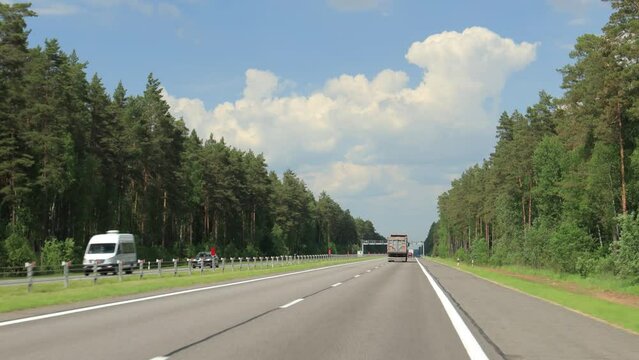 Road view on a summer day. Highways and cars, roadside and white road line markings.