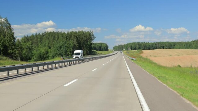 Road view on a summer day. Highways and cars, roadside and white road line markings.