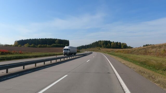Road view on a summer day. Highways and cars, roadside and white road line markings.