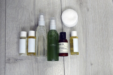 Fototapeta na wymiar Jars with cream, shampoo and cosmetics on a background with green plants