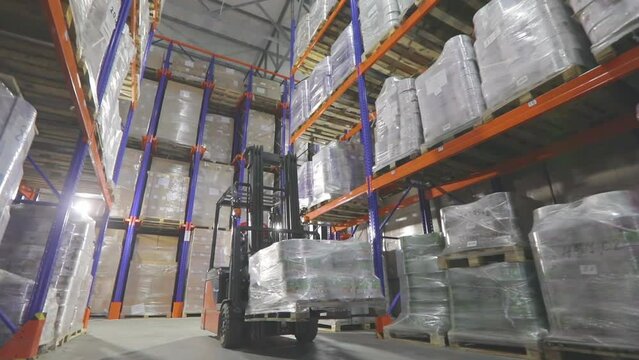 A worker on a forklift will perform work in a warehouse. Large modern warehouse. Warehouse work