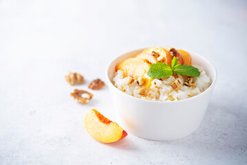 Sweet caramel rice porridge with caramelized peaches and walnuts in a bowl