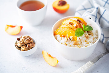 Sweet caramel rice porridge with caramelized peaches and walnuts in a bowl