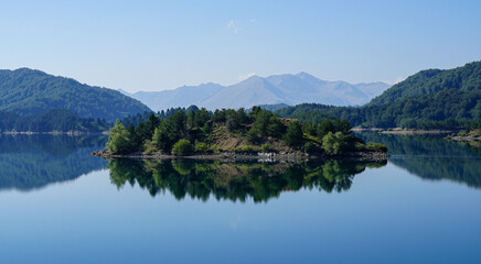 Fototapeta na wymiar Wonderful Aoos Lake near Metsovo in Epidurs. Beautiful Mirror Reflection of the surrounding mountains in the water.