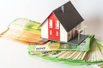 Private house model and euro banknotes, house construction costs.