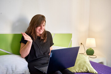 Closeup of the woman with an awkward face looking at the laptop.