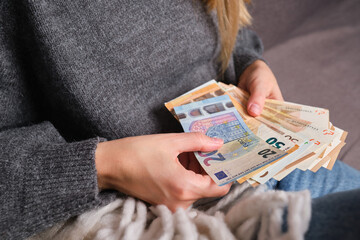 Woman holds money in her hands. Cash in euros for payment or exchange. A woman counts his salary in euro banknotes. Saving money, bank deposit withdrawal. European money. Financial crisis. Hands close