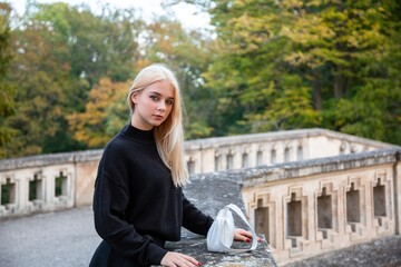 Girl posing in the autumn park with river and trees