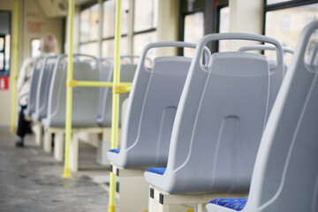 Naklejka na ściany i meble Plastic seat backs in an empty interior of a city tram, trolleybus or bus. Inside view. Selective focus. Small zone of sharpness.