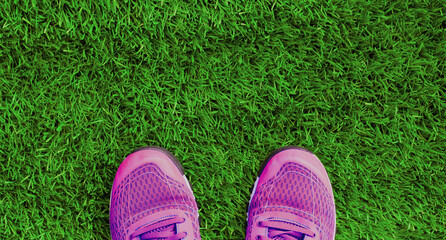 Close up summer sports sneakers on green grass background, top view