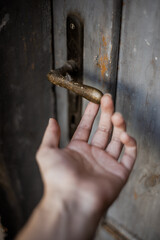 Hand reaching for a handle of a door
