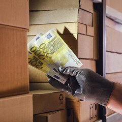 Euro money in the hands of a male warehouse worker. Payment for the delivery of goods and finance...