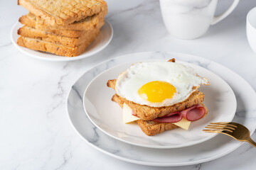 Sandwich with a fried egg, bacon, cheese and spinach