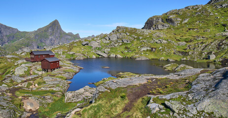 Munkebu Hut, a very popular destination in a day trip hike in Lofotens. Wilds of Lofoten mountains landscape with relatively well traveled trails. Small lake at the foreground. Vacation in Lofoten.