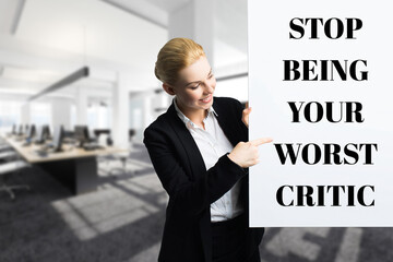 smiling businesswoman in front of a wall with the message STOP BEING YOUR WORST CRITIC