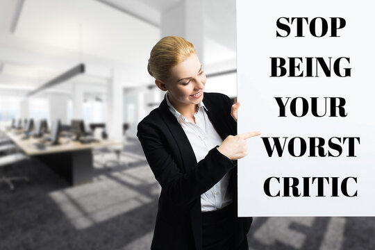 smiling businesswoman in front of a wall with the message STOP BEING YOUR WORST CRITIC