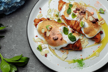 croissant with sweet cream and almonds on a plate. Delicious and healthy breakfast
