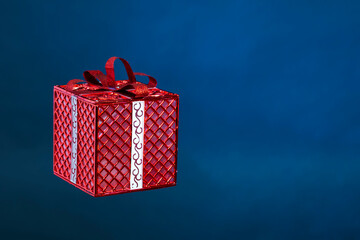 Gift box tied with a red ribbon on a blue background
