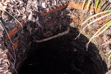 Unclosed old brick well, dangerous hole in the ground