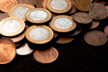 several coins of brazilian money  on the black background