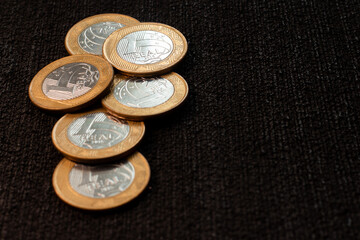several coins of brazilian money  on the black background