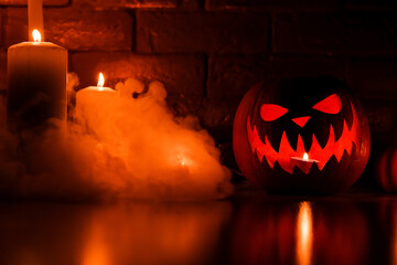 Halloween's holiday attributes. Halloween. carved pumpkin. candles . smoke . dark scene. pumpkin head silhouettes.