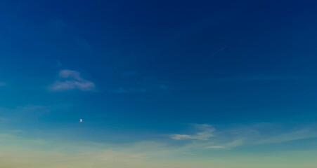 Naklejka na ściany i meble Luna bianca nel cielo azzurro e scia di aereo