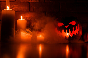 Halloween's holiday attributes. Halloween. carved pumpkin. candles . smoke . dark scene. pumpkin head silhouettes.