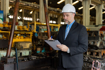 A businessman checks on-site maintenance work at an old factory for train rehearsals.