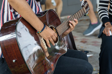 latina woman playing guitar in the street, young brunette woman, latin america