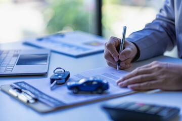 Car rental sales concept, Asian businesswoman working with toy cars on the table. Concepts of cars, property, ownership, insurance and transportation.