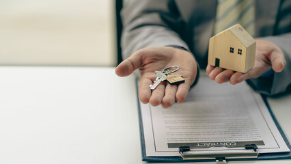 Sales representatives hand out the house keys to customers after signing a contract to buy a house...