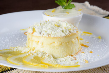 dulce de leche pudding with sugar syrup and tasty sour cream in powder, served on a white plate