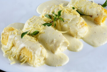 rondelli and cannelloni pasta in white sauce with parmesan cheese