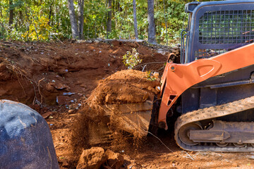 Small tractor used to move soil for landscaping on construction site.