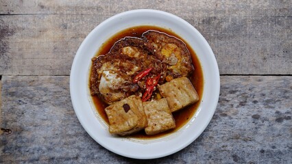 Semur telur dan tahu. Is Indonesian traditional side dish made with sunny side up and tofu cooked with soy sauce and some spices like cinnamon, coriander, pepper, garlic, shallots and chili 