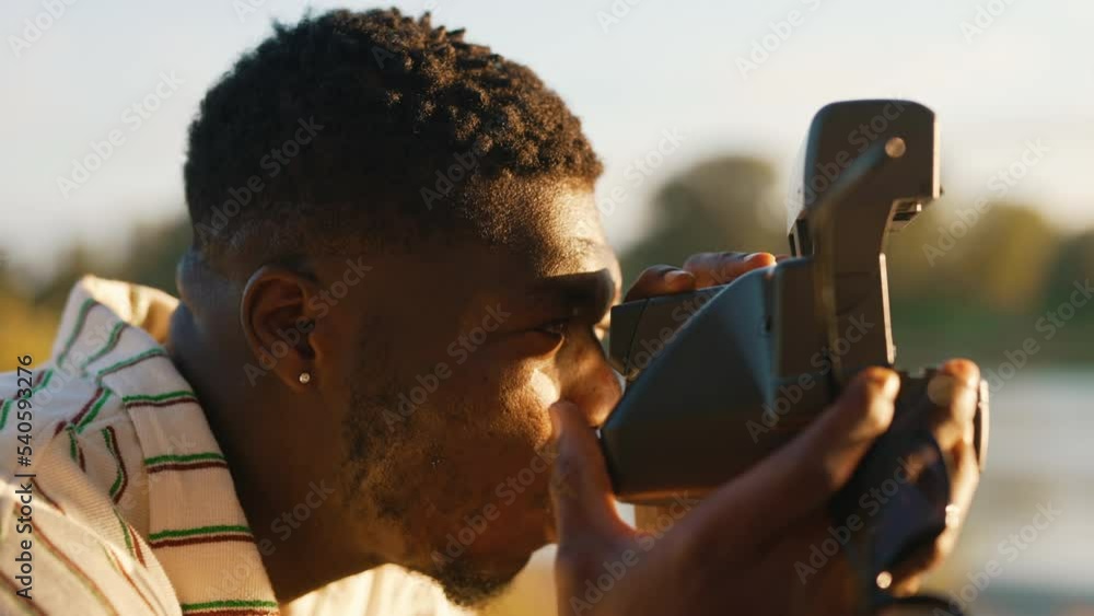 Wall mural outdoor closeup portrait of middle-aged black man with facial hair taking of his sunglasses to take 