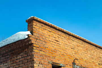 Brick brown old wall covered with snow