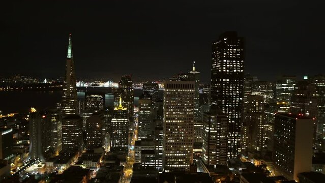 Aerial Lockdown Shot Of Illuminated Modern Buildings In City Against Clear Sky At Night - San Francisco, California