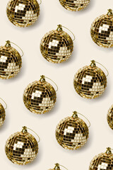 Minimal New Year party concept. Christmas greeting card, monochrome vertical holiday background. Graphic Pattern with golden mirror balls on beige background, shiny disco ball as Christmas toy