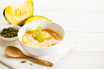 Pumpkin soup in a white bowl.