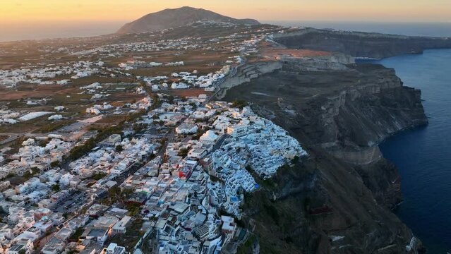sunrise on Santorini, aerial view of the traditional Greek town of Thera or Fira, flying above Greek island of Santorini, vacations on Greek islands