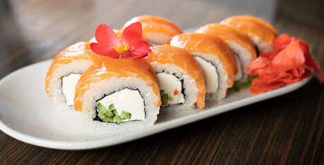 Philadelphia sushi roll with salmon cream cheese on a plate. Traditional Japanese food.