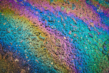 Puddles are contaminated with multicolored streams of oil.