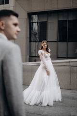 Woman wearing wedding dress posing outdoors with handsome man.