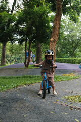 Portrait little cute adorable asian kindergarten boy in safety helmet enjoy having fun riding exercise bike