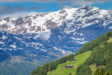 Fototapeta na wymiar Snowcapped mountains in Stelvio national park with farms, Valfurva, Italian alps