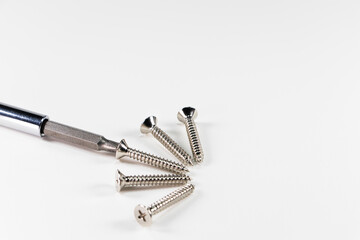 Screwdriver and tapping screws on white background