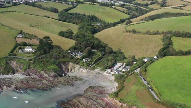 Wide aerial view of Talland Bay on the Cornish coast, revealing surrounding countryside landscape