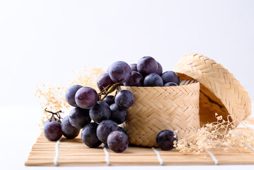Black grape in bamboo basket on white background, Healthy fruit